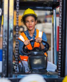 Woman worker at forklift driver happy working in industry factory logistic ship